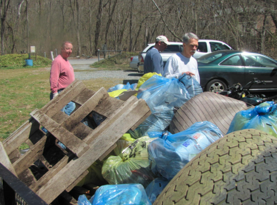 Mike Kutzleb (right) and other volunteers load the 48 bags of trash and other debris they cleaned up into a trailer for disposal.